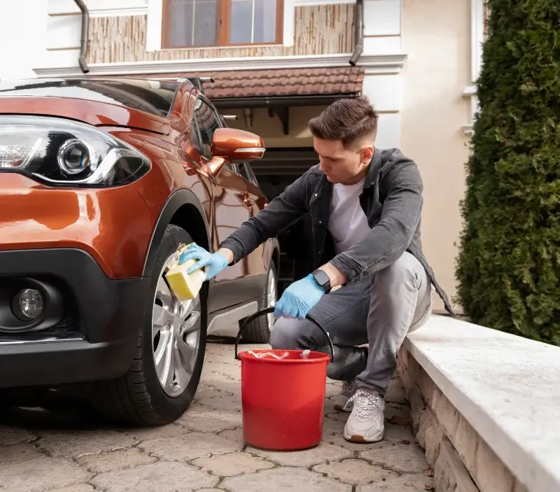 Lavage auto à domicile Le Mesnil-Thomas : professionnel intervenant sur un véhicule